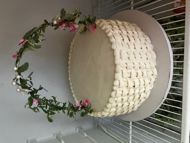 Ivory basketweave cake with a floral arch