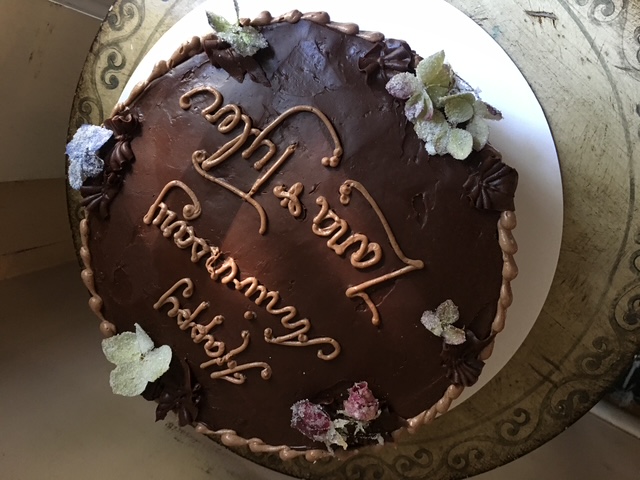 Chocolate celebration cake with hand-piped lettering and flowers