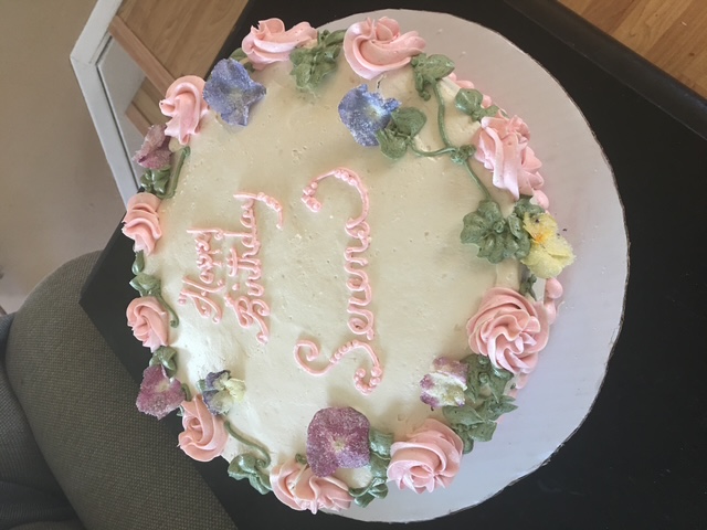 Birthday cake with pink buttercream flowers and colorful blossoms