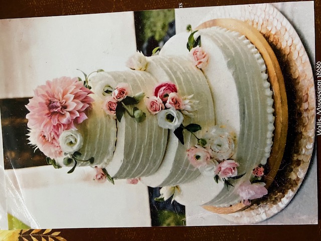 Three-tier wedding cake with pink and ivory flowers